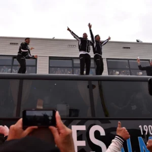 Feestvierende Heracles spelers op bus